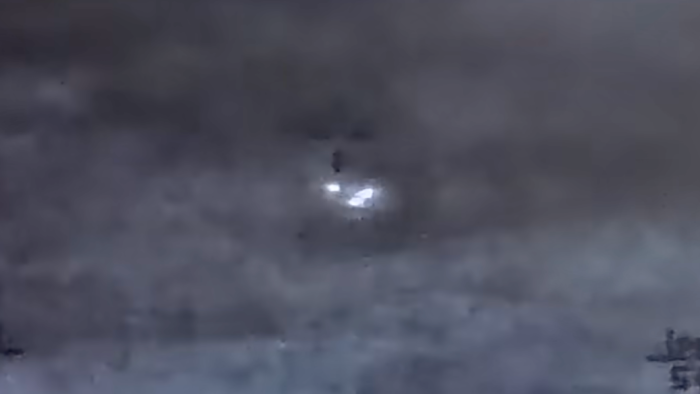 Triangular UFO captured by military sensor during podcast discussion, formation confirmed.