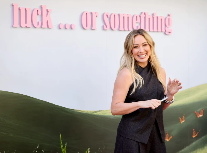 Hilary Duff at an event, discussing motherhood and celebrity controversy