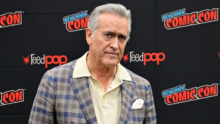 Bruce Campbell smiling at an event, fans supporting him during cancer battle.