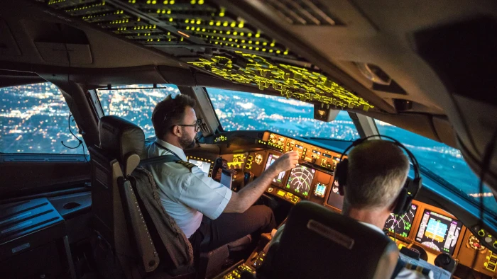 Pilot holding soda water and wiping aircraft glass during safety-focused cleaning.
