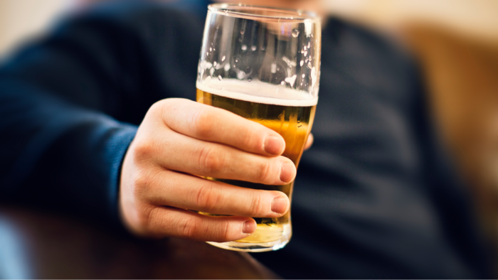 Man holding a drink while discussing erectile function and alcohol effects