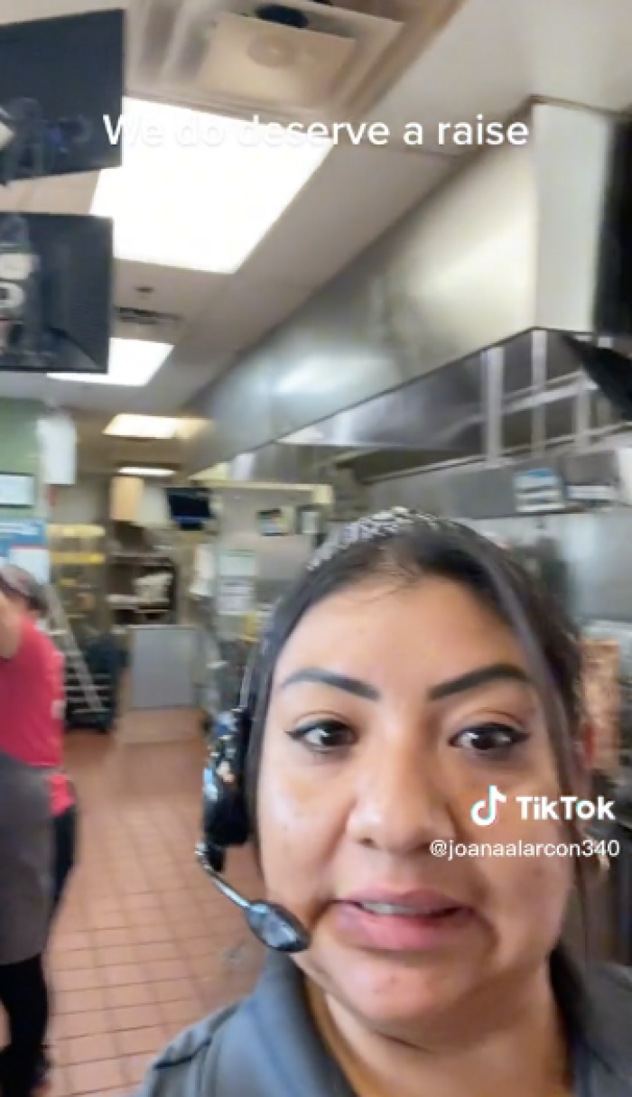 The TikToker shows herself with her coworkers, lots of customers, and something beeping in the background.