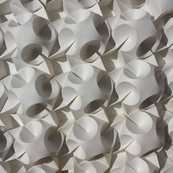 Large kiss-shaped paper fold sculpture with connectors, blending hobby origami into art.