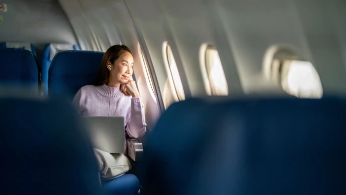 Person wearing breathable natural-fiber clothing and scarf for safer air travel