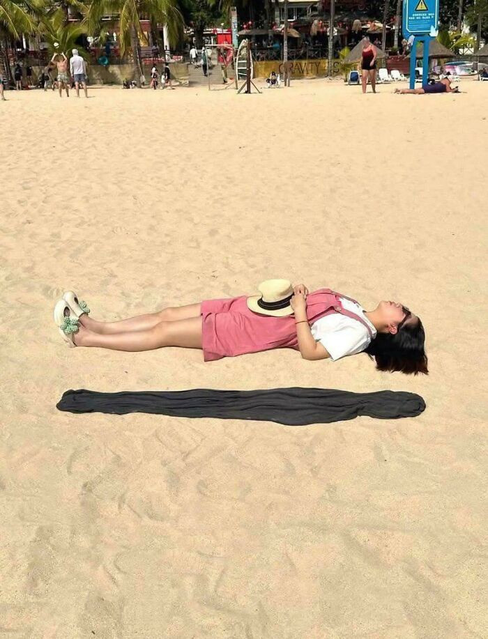 "This Rolled Up Black Dress On The Beach Looks Exactly Like A Detached, Glitched Shadow"