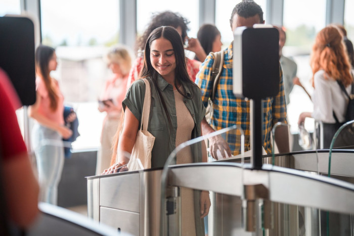Traveler at airport kiosk submitting biometric data for European entry system.