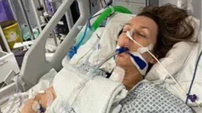 Community support gathering for domestic violence survivors, wheelchair user receiving help.