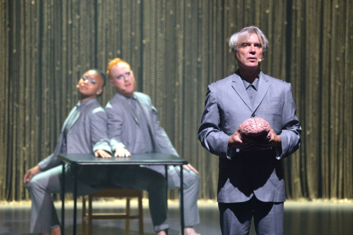 David Byrne performing on stage, fans watching, Keller Auditorium tour buzz