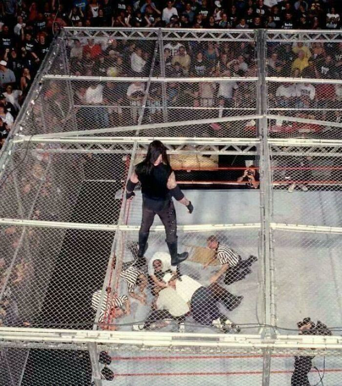 "The Undertaker Looks Down At Medical Staff Checking On Mankind After He Fell, Unscripted, Through The Top Of H**l In A Cell Into The Ring 16ft Below. June 28, 1998"