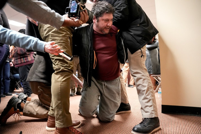 Town hall event scene, local resident detained after non-toxic substance incident