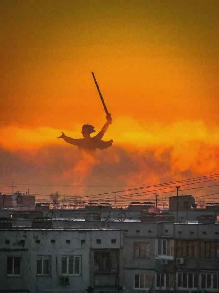 The "Motherland Call"S War Memorial Stands Against A Backdrop Of Dilapidated Residential Buildings In Volgograd, Russia