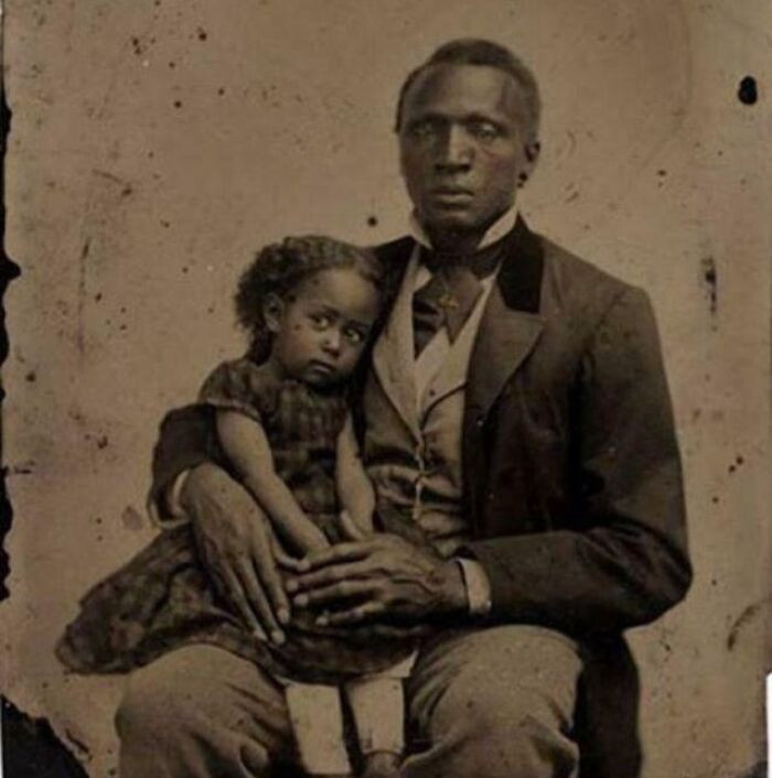 A 19th-century tintype showing a gentleman posing with his young daughter, photographed in the 1870s.