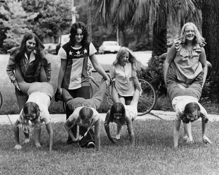 "Photographers Dughi's Sisters And Other Girls Hold A "Wheelbarrow" Race On The Front Lawn - Tallahassee, Florida, 1974"