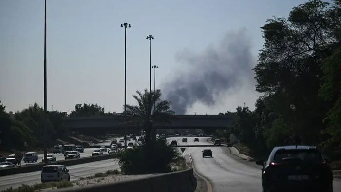 Closed airport gate signage and stranded passengers, reflecting evacuation frustrations.
