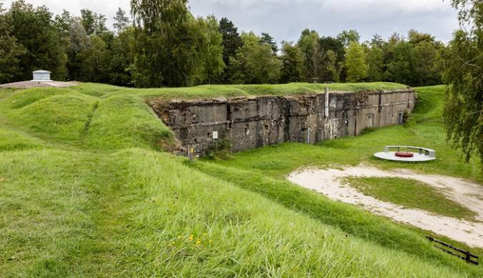 Barbed wire and warning signs mark the Zone Rouge WWI battlefield.