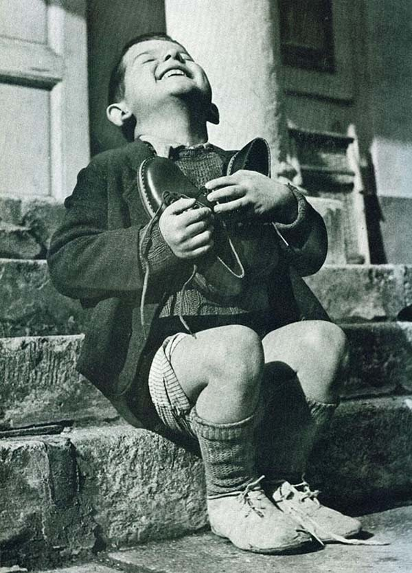 20. An Austrian boy is excited about his first pair of new shoes in years (1946).