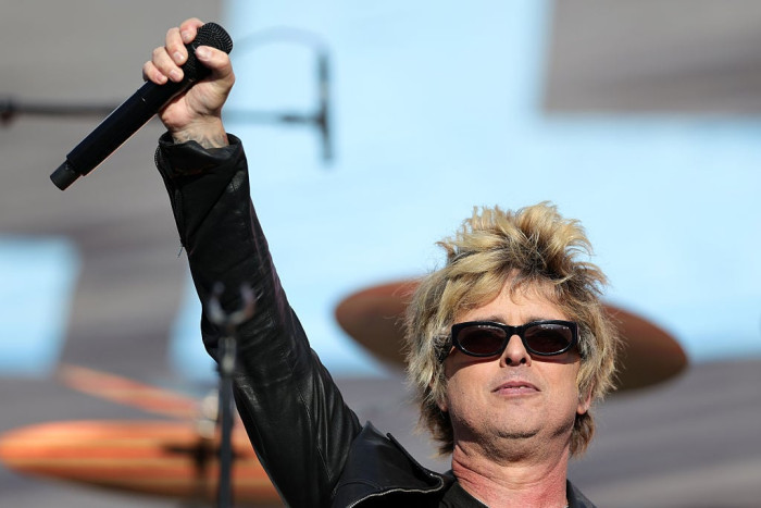 Green Day performing on stage, fans anticipating political remarks at Super Bowl.