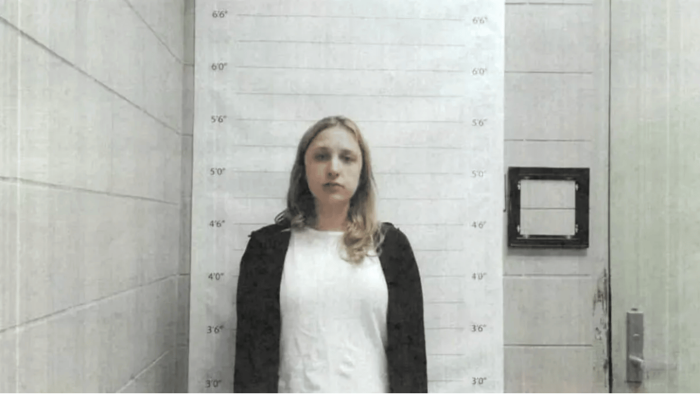 Newspaper headline about educator arrest and alleged inappropriate messages on device
