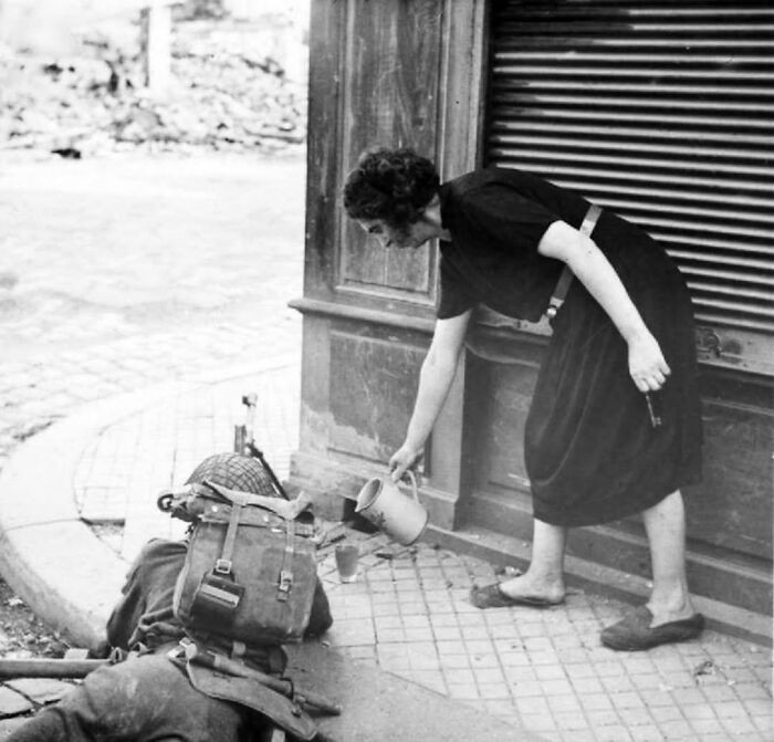 "A French Woman Pouring Cider For A British Bren Gunner In Lisieux, France. August, 1944"