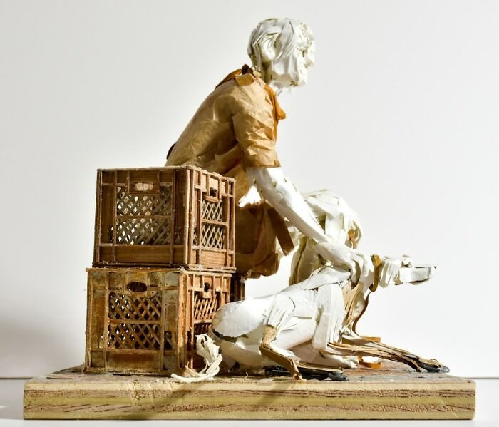 Sculpture titled The Seeker Letting Go, folded paper figure emerging from shadowy void