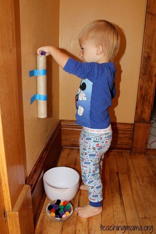 11. Tape a paper towel roll to the wall to make a simple game for your toddler