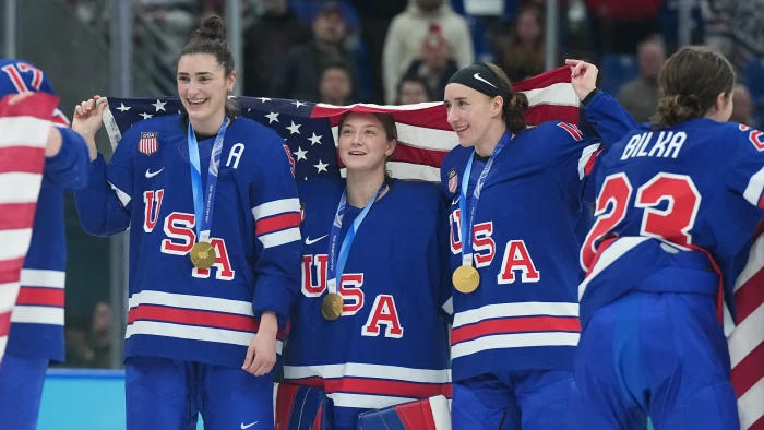 Women’s ice hockey players holding gold medals after State of the Union call