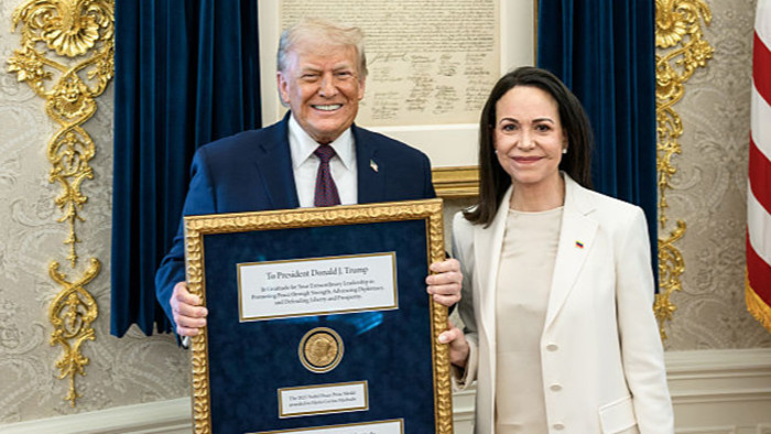 Nobel Peace Prize ceremony moment with Venezuelan opposition figure and Donald Trump gesture