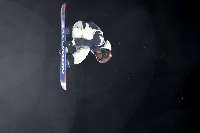 Snowboarder at Winter Olympics opening ceremony wearing bib on one shoulder