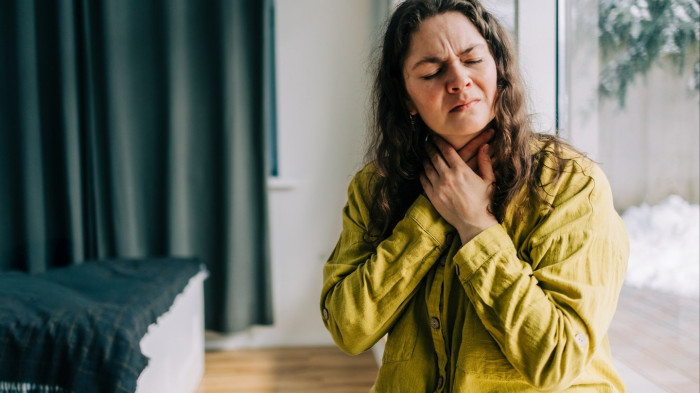 Person demonstrating safe self-administered abdominal thrust technique for choking relief
