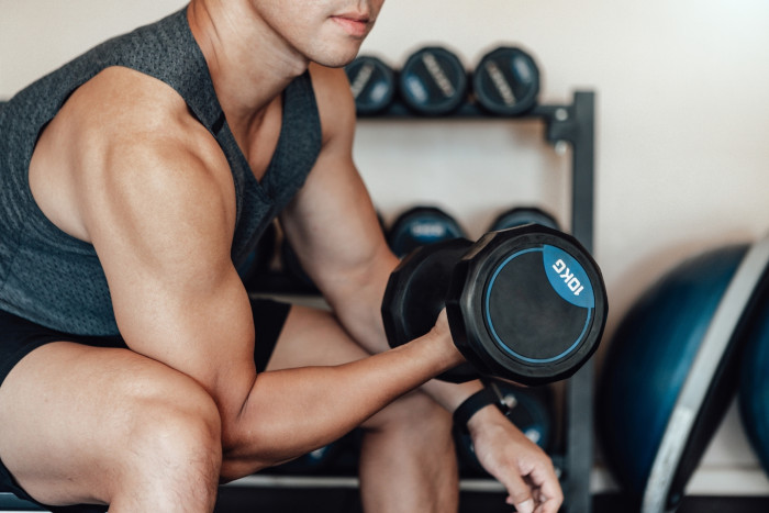 Trainer guiding a client through strength workout movements at the gym