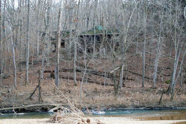 The house happens to be across the river from his property, and no one knows who owns it