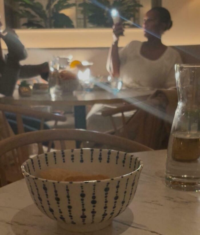"At A Dimly Lit Dinner Next To Influencers Who Brought Their Own Light"
