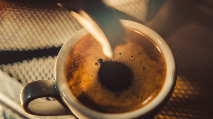 Decaffeinated coffee cup and beans highlight caffeine-free beverage options for sleep hygiene