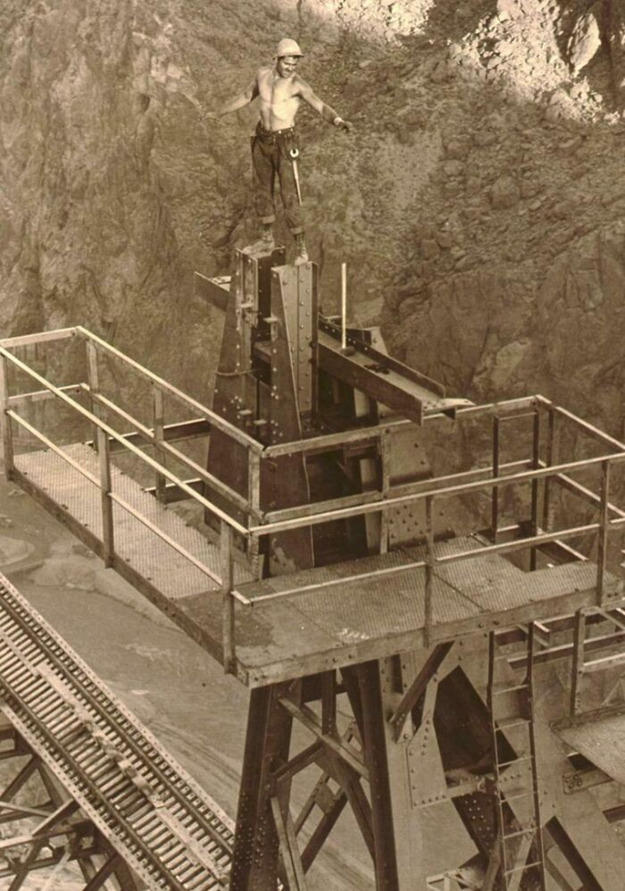 A rigger stands high on a cableway headtower as work progresses on the Boulder Dam in Boulder City, Nevada, captured during the massive construction effort of 1934.