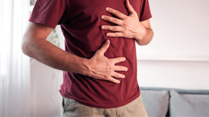 Person in emergency room setting after severe abdominal pain, colorectal awareness message.