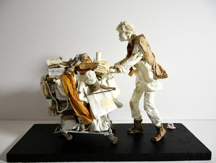 Sculpture titled The Purse Thief, fragile folded paper form with suspended, fallen pose