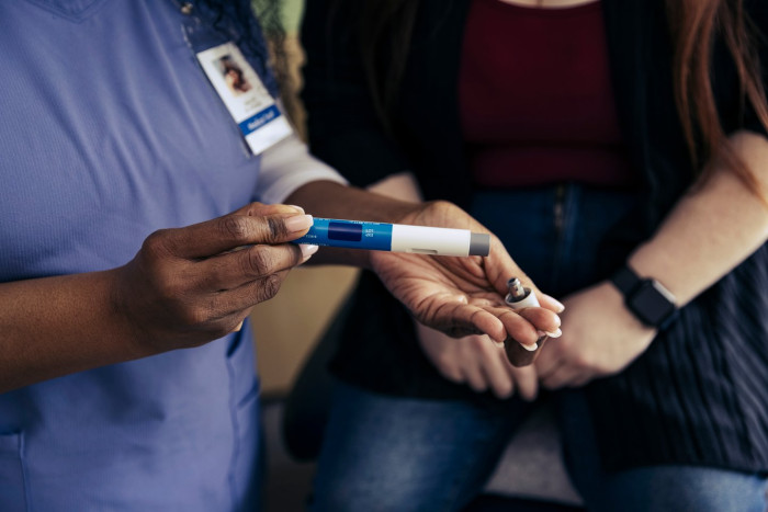 Woman holding medication prescription, symbolizing rapid weight loss and rising health concerns