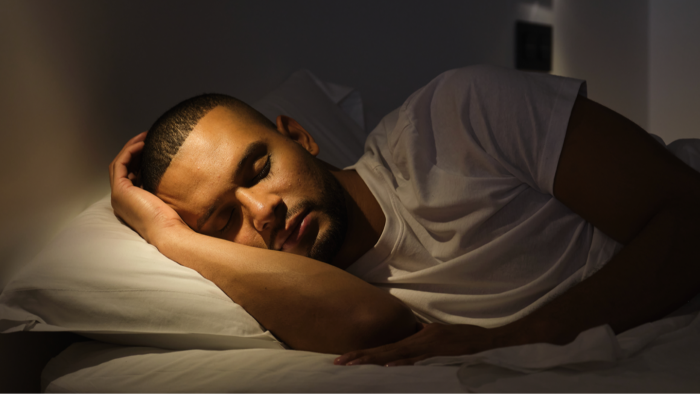 Person resting in bed at night, calm bedroom lighting and sleep focus