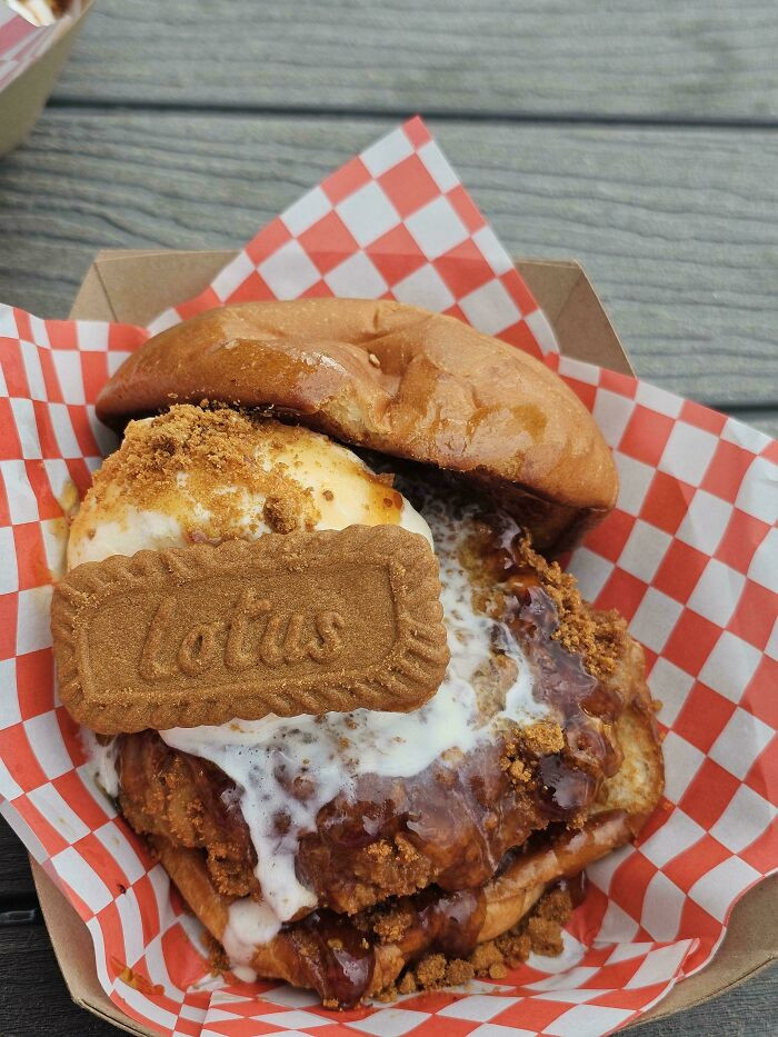 "Biscoff-Breaded Fried Chicken Breast Biscoff Ice Cream Sandwich With Biscoff Cookie, Biscoff Topping, And Smoky Maple Hot Honey On A Brioche Bun"