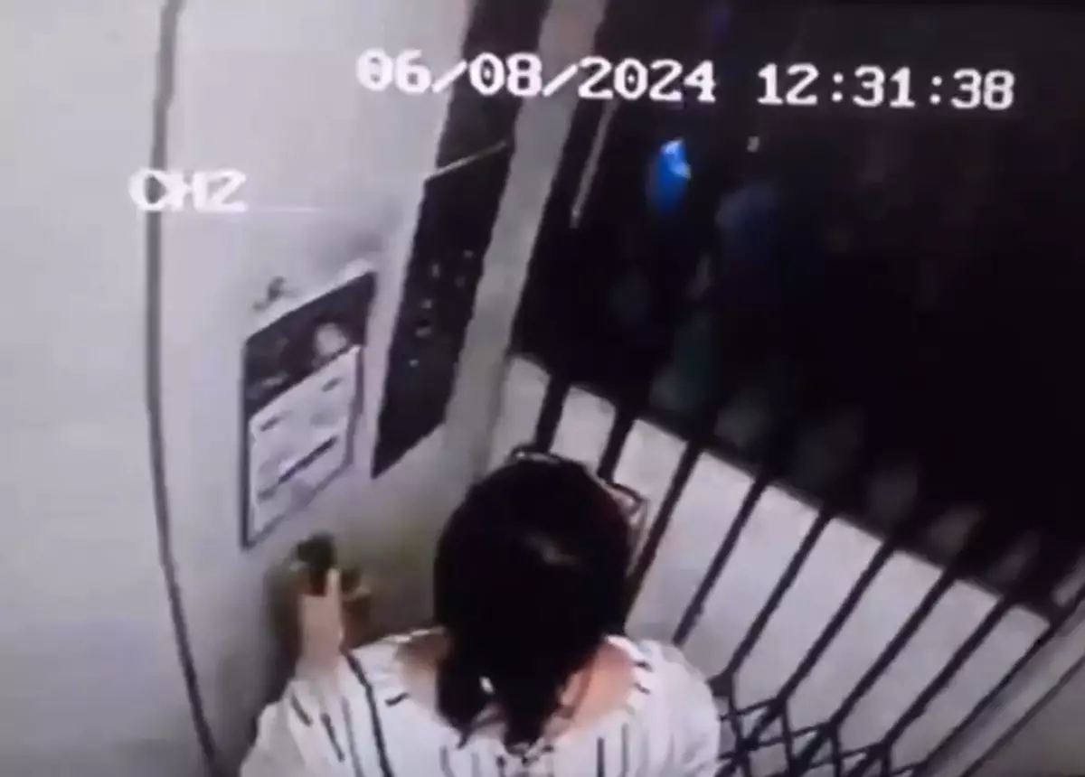 The footage, taken by a security camera, shows one of the men closing the door before Adriana presses a button.