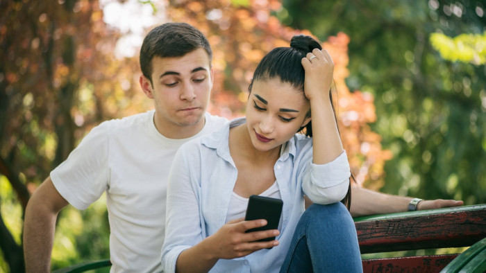Phone screen with spyware alert context, warning of battery drain and call monitoring