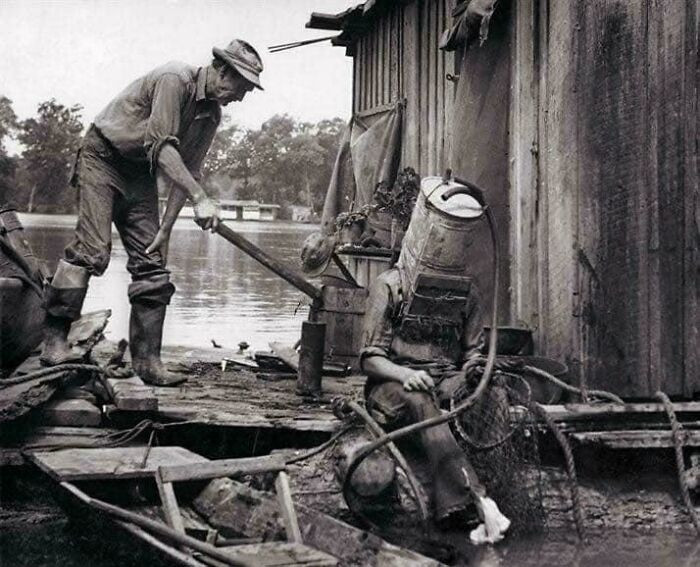 "A Mississippi River Pearl Diver, Using A Car’s Old Gas Tank For A Helmet, Prepares To Descend Into The River. 1938"