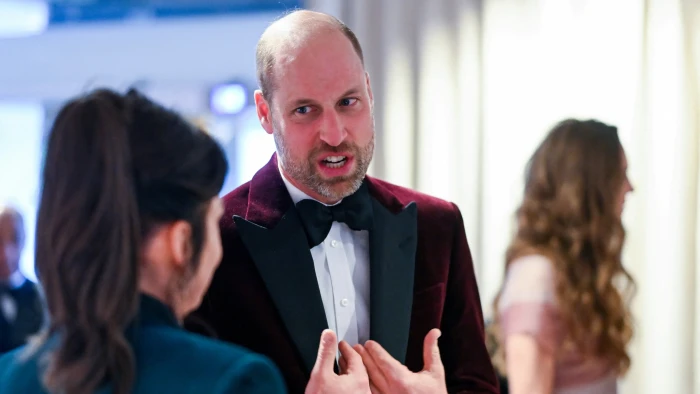 Prince William and Andrew Mountbatten-Windsor stand with security nearby after arrest news.