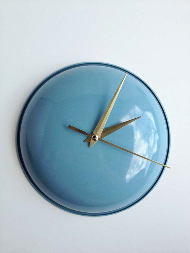 8. This clock is crafted from repurposed materials: an old pot lid and a clock mechanism.