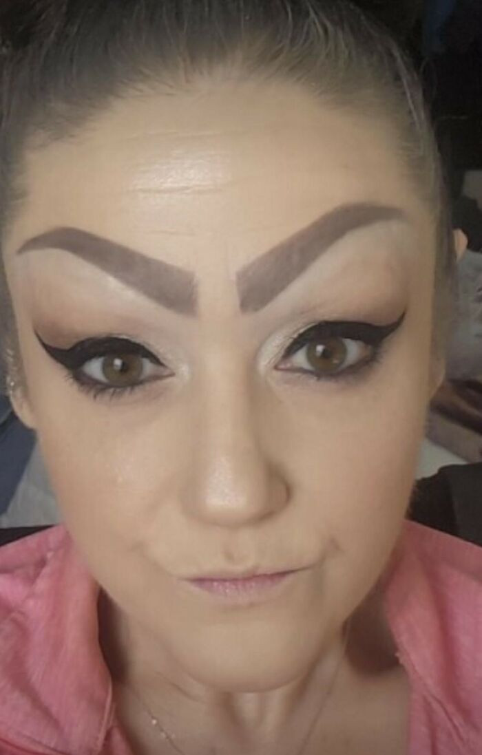 Close-up of face with dramatic, overdone bold brows, beauty trend commentary.