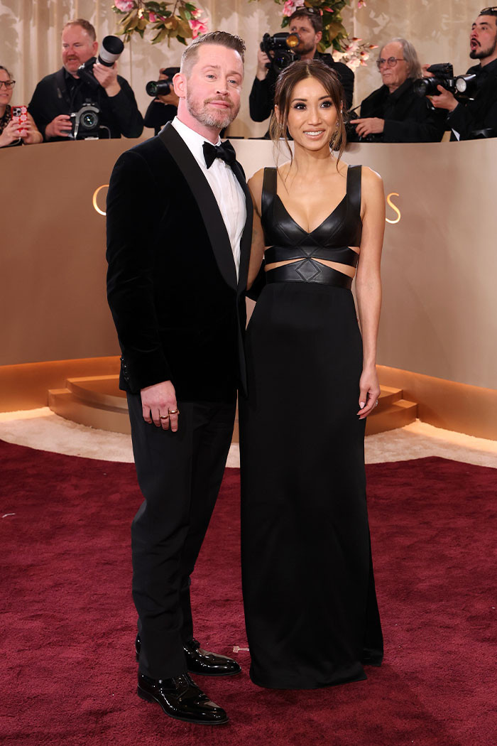 Macaulay Culkin kept it classic in a sharp black tuxedo with a white shirt and bow tie, while Brenda Song made a statement in a sleek black gown with bold cutout details, finished with minimal jewelry and a polished hairstyle.
