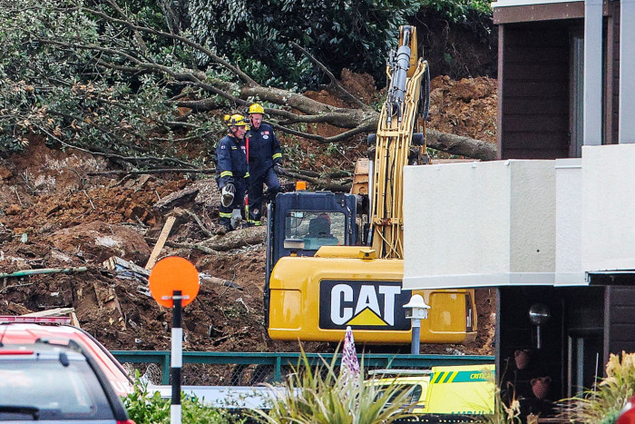 Tourists and locals near a campsite, recalling a catastrophic New Zealand landslide