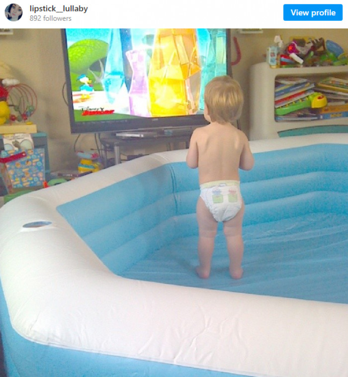 14. This father inflating an inflatable pool for his child to play in. In the living room...