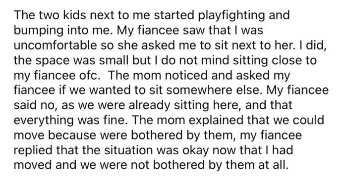 The OP moved to the other side of the table next to her fiancé because the large family had two children who were being boisterous.