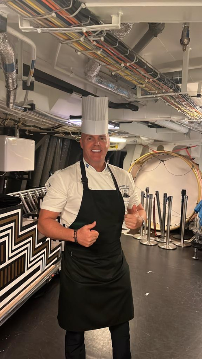 Chef on Royal Caribbean cruise ship preparing meals with sustainable sourcing.